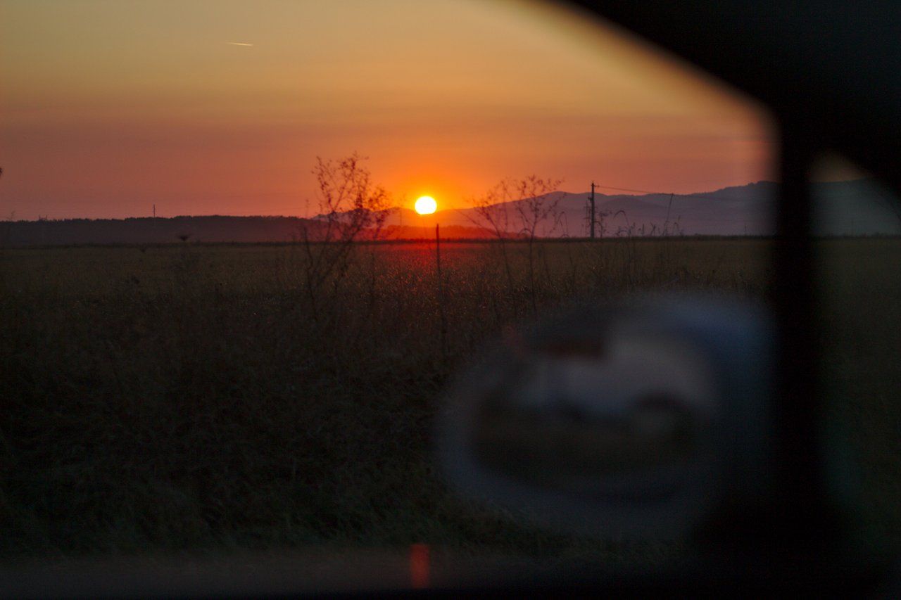 sun setting seen from the road