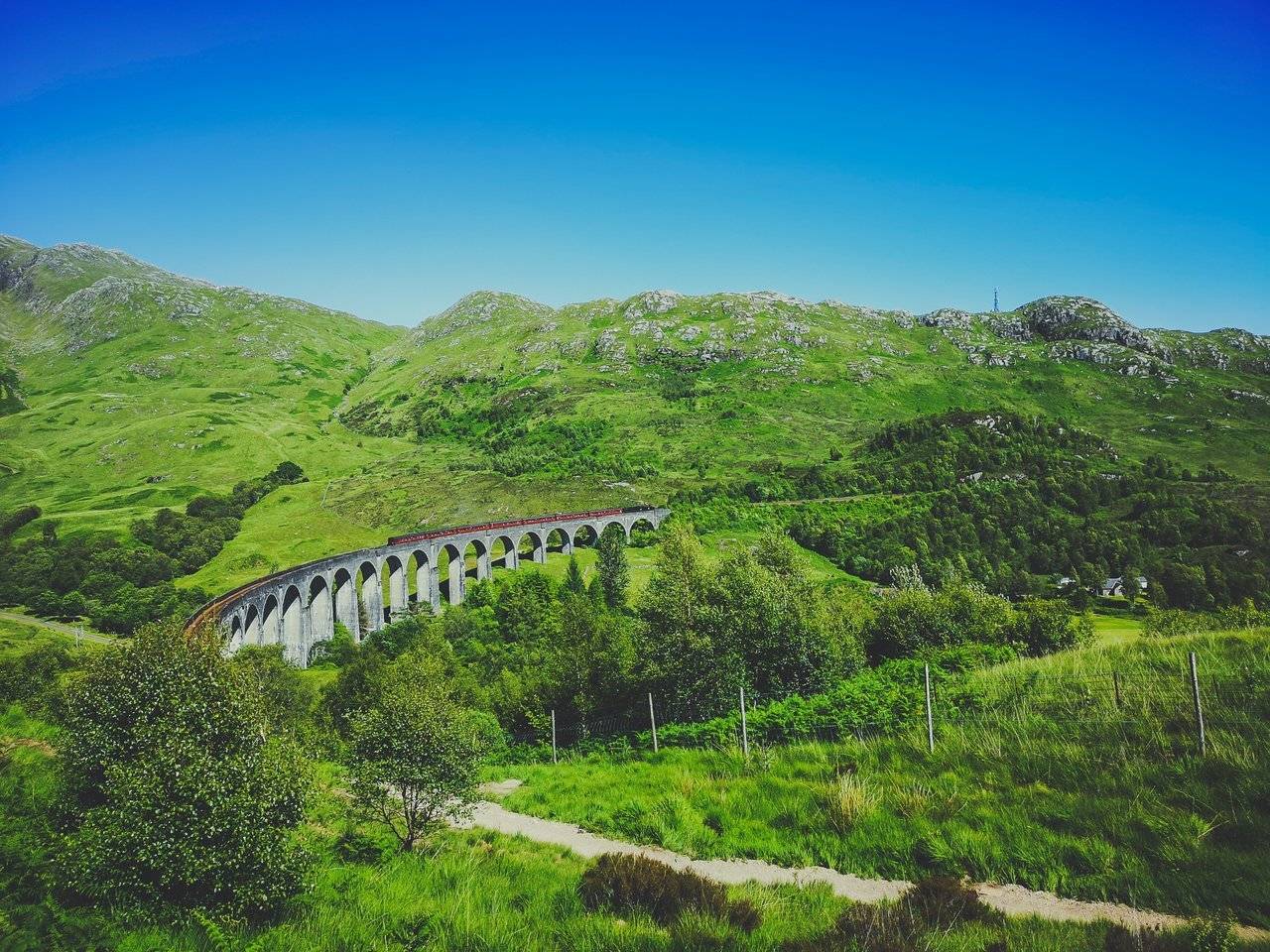   The Jacobite train on Glenfinnan Viaduct from Mallaig could be seen 15 minutes after the one rolling from Fort WIlliam. Photo by Alis Monte [CC BY-SA 4.0], via Connecting the Dots