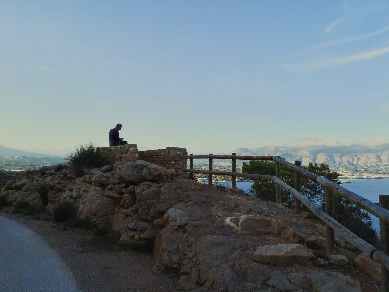   Man sitting on a rock on Camino del Faro. Photo by Alis Monte [CC BY-SA 4.0], via Connecting the Dots