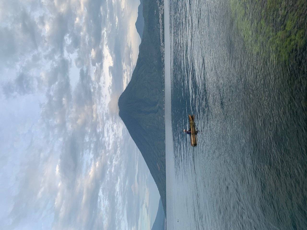 A fisherman in a kayuco on Lago Atitlan in front of San Pedro 🌋 