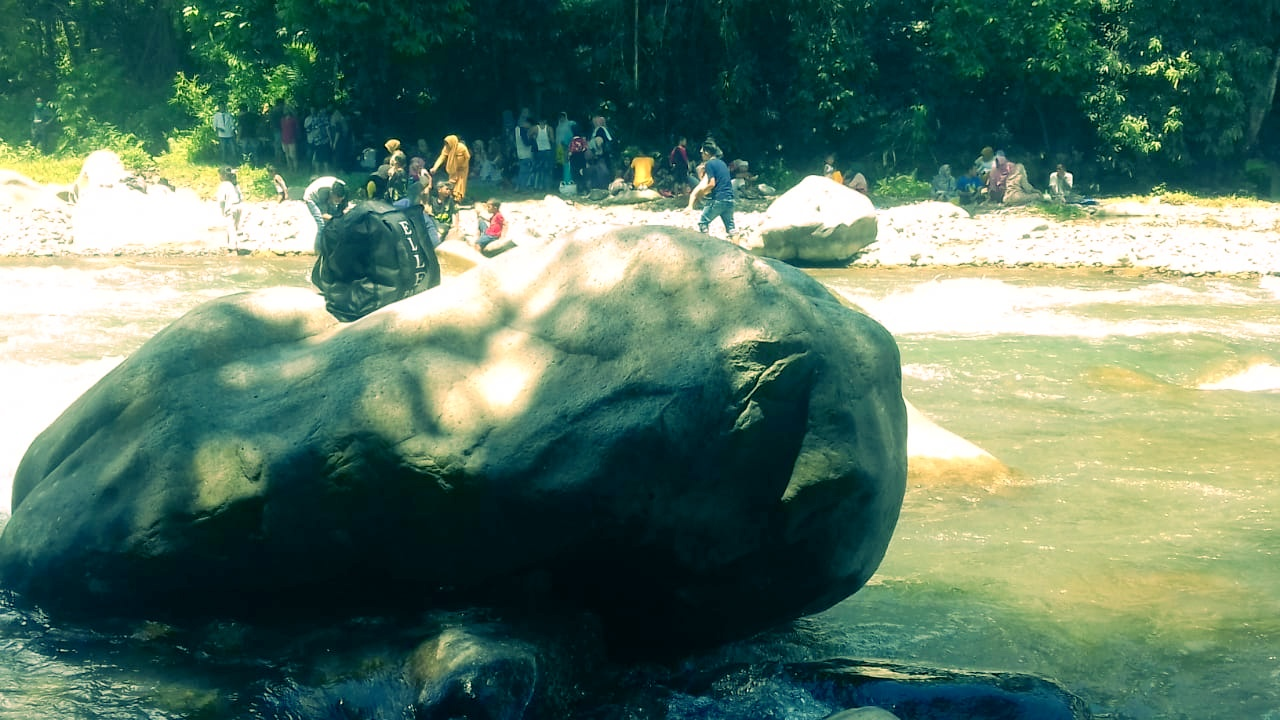 A picture of a large rock on the banks of the Krueng Geunie River,