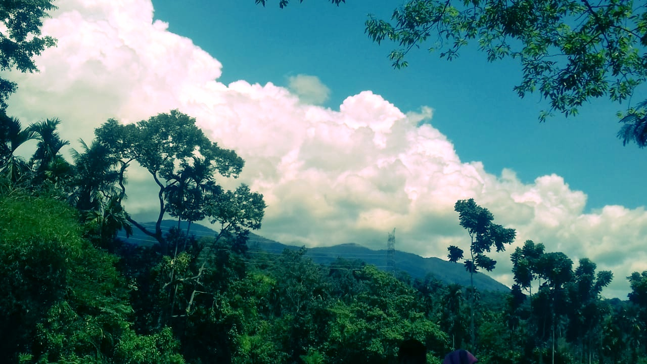 visible clouds, mountains, and trees around it.