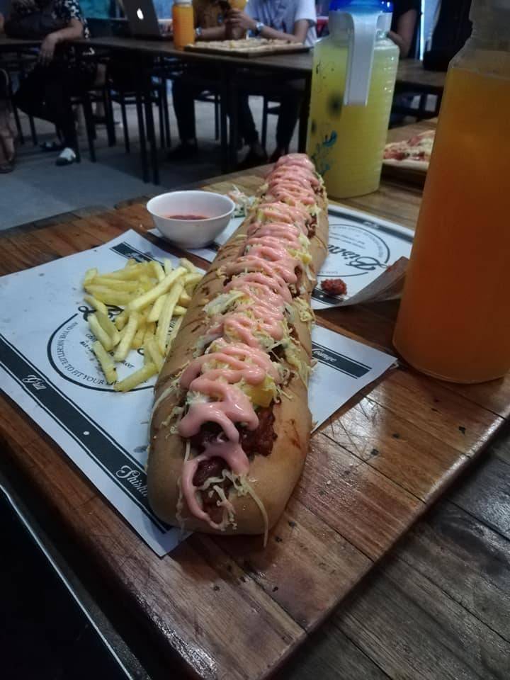 Giant hotdog sandwich with fries and pitcher of drinks (sliced to 8 pieces)