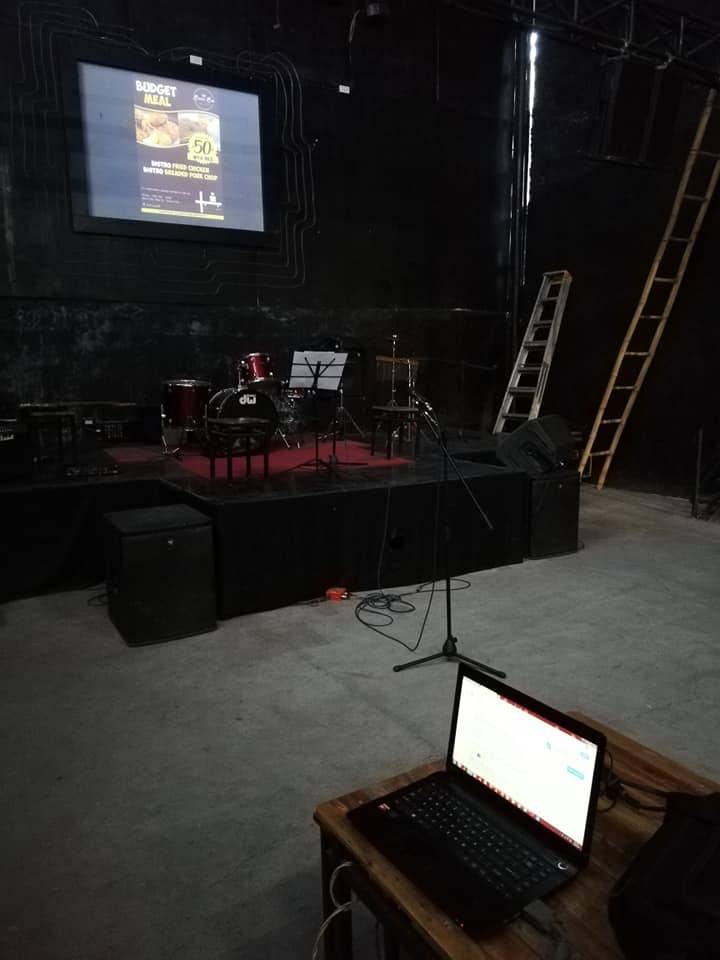 What a setup! A projector screen at the top? And musical instruments on stage?