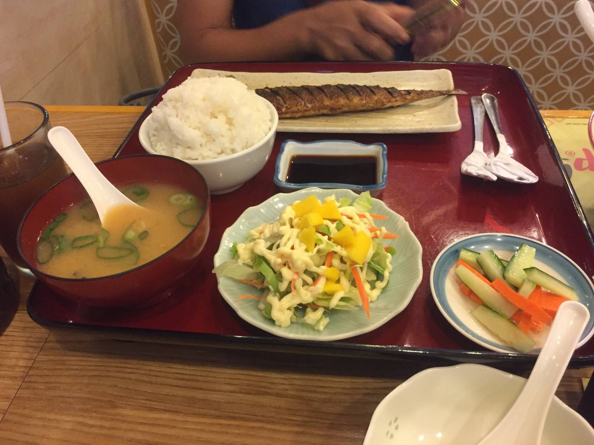 Fried fish with miso soup, mixed veggies with salad dressing, sliced cucumbers and carrots with one cup of rice.