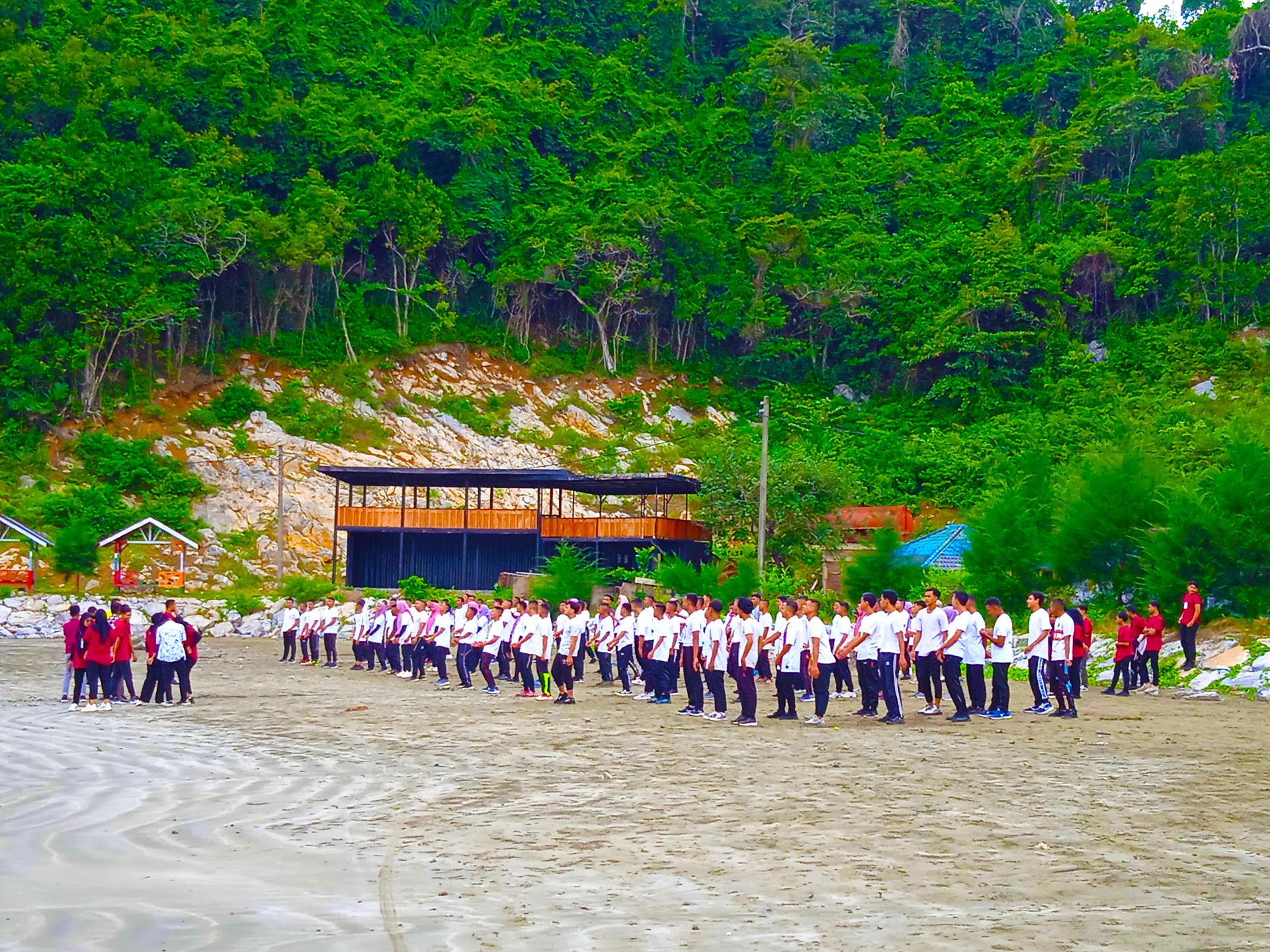 They are college kids or college kids who are doing marching exercises on the beach.