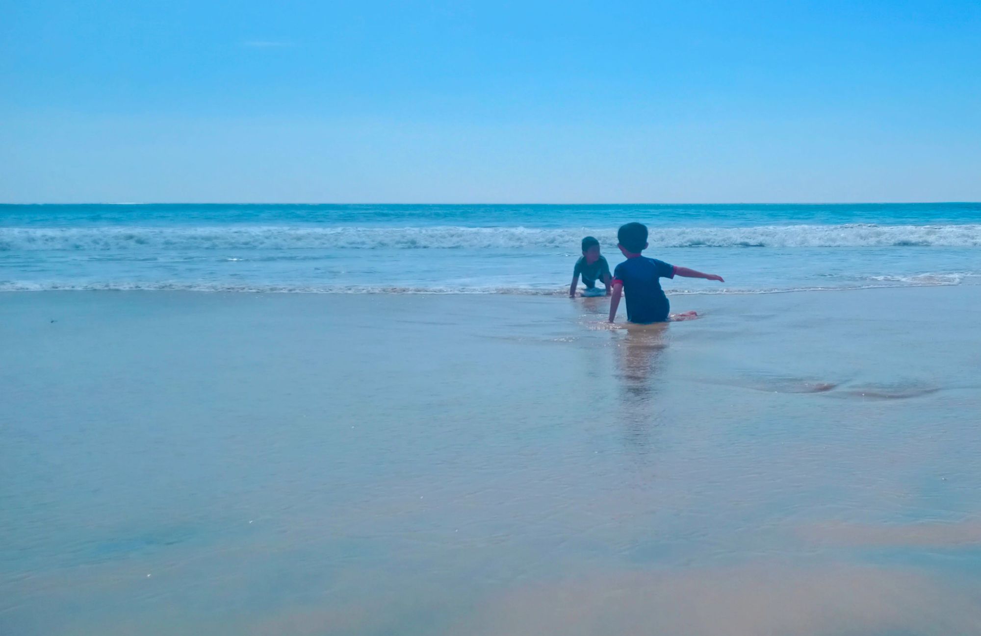 Little boy playing in the water on the beach,