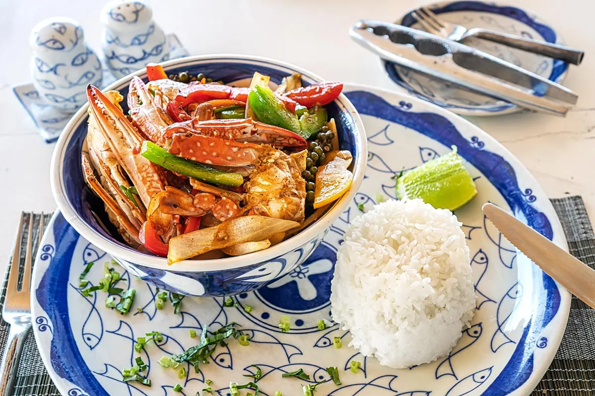 Stir-fried Kep crab with vegetables and a pod of fresh green Kampot peppercorns.