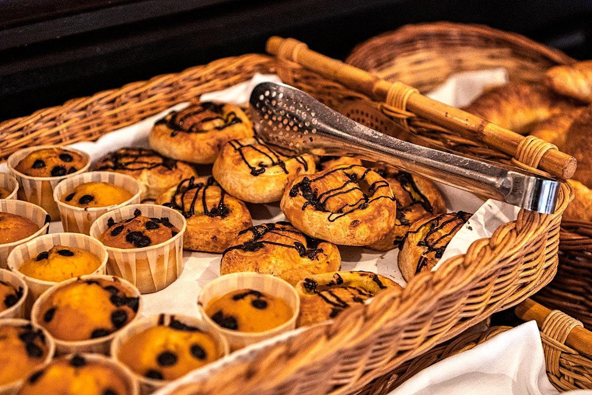 Chocolate muffins and raisin rolls next to the croissants.