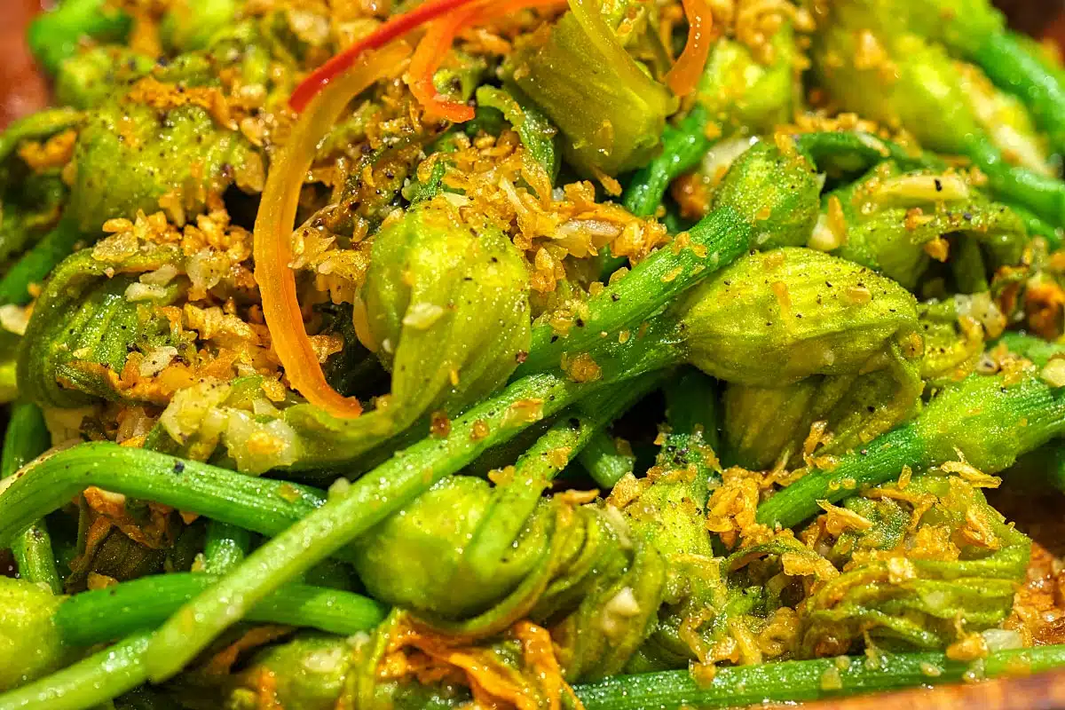 Stir-fried pumpkin blossoms with crispy fried garlic