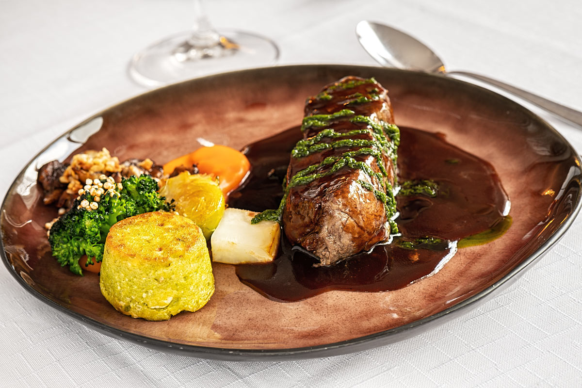Saucy roast beef with vegetables, mushrooms, and herbal souffle on the side.