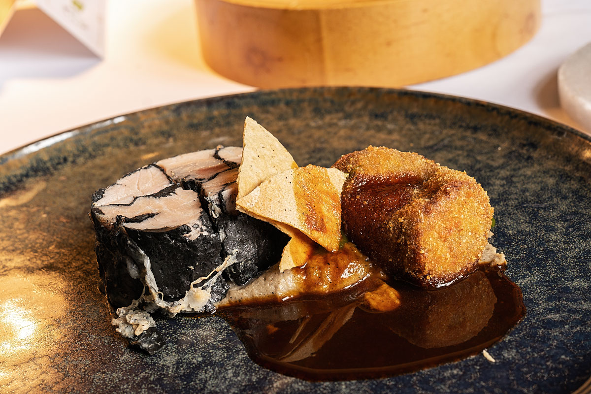 Pork with reduced jus, celeriac puree, celery drops, and fritter