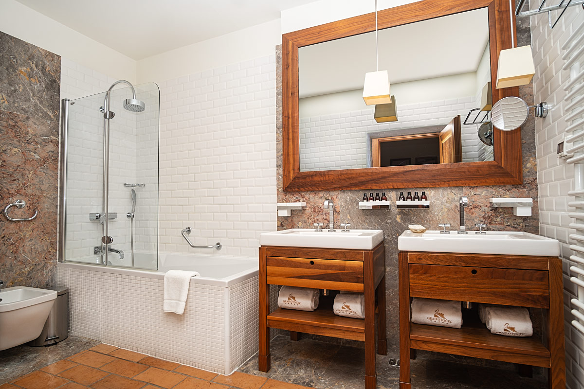 The spacious bathroom has double sinks and a bathtub with an integrated shower.