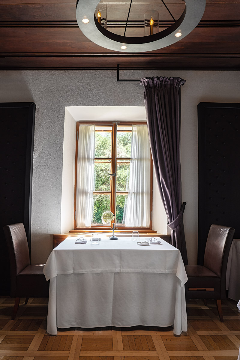 An intimate table by the window reflects the quiet elegance of the Otočec Castle restaurant.