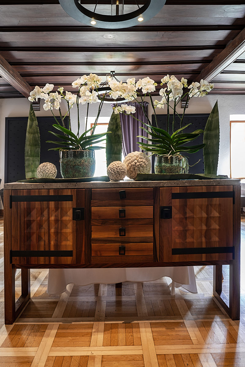 Restrained floral arrangements and restored wooden furniture soften the historic interior.