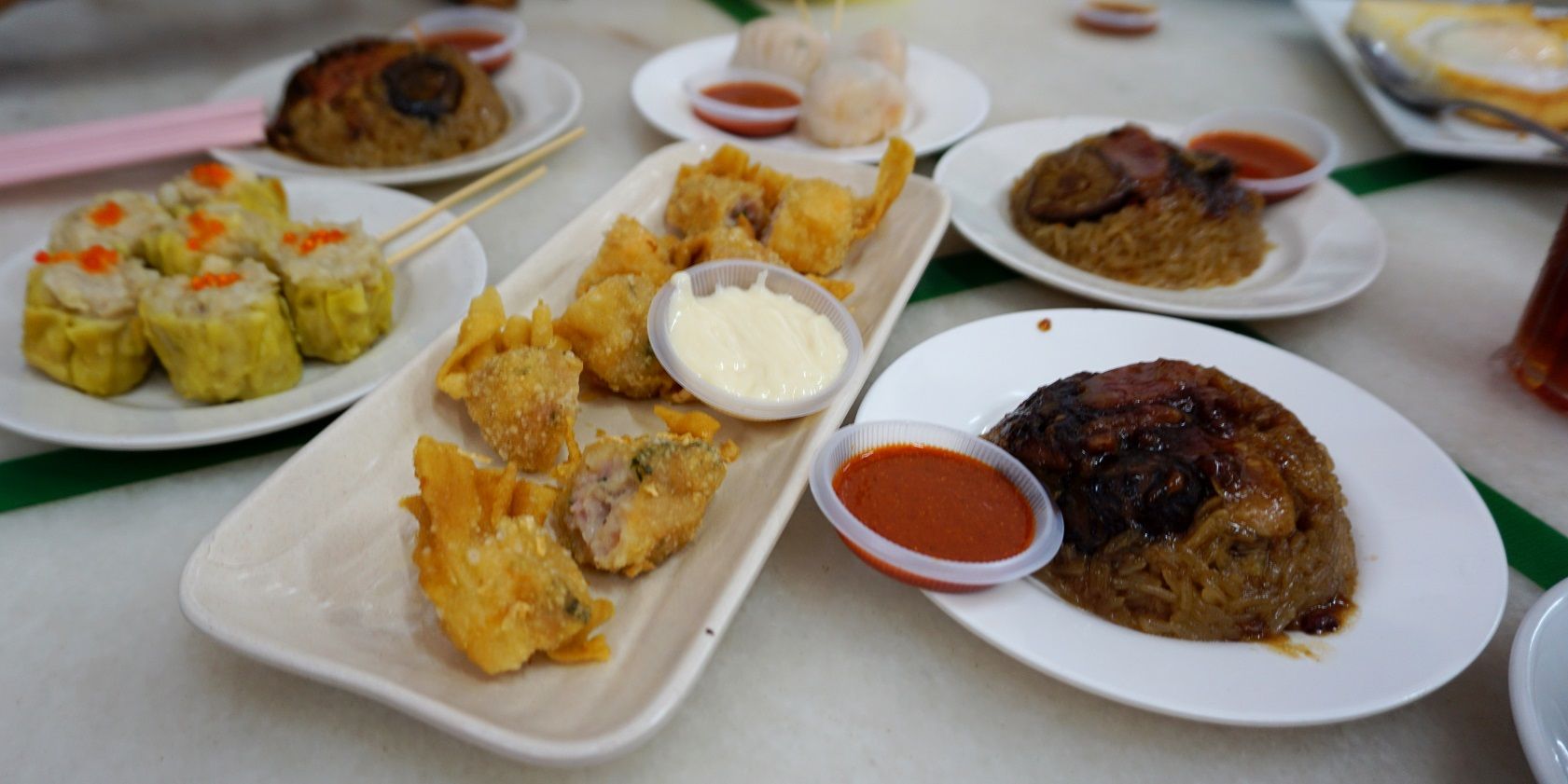 Some dim sum - siu mai (left), har gow (top, centre) and fried wan tan on long rectangular tray, centre... And loh mai kai - the three saucers of glutinuous rice topped with chicken pieces and Chinese mushroom