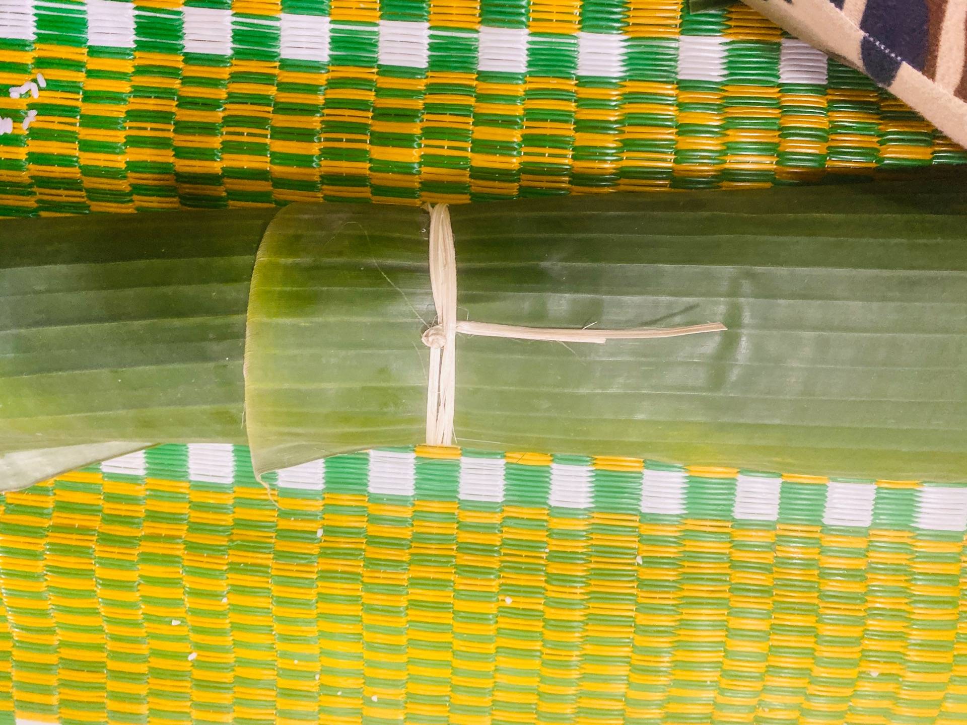 Roll the Banh Tet and tie it together with a Bamboo string. 
