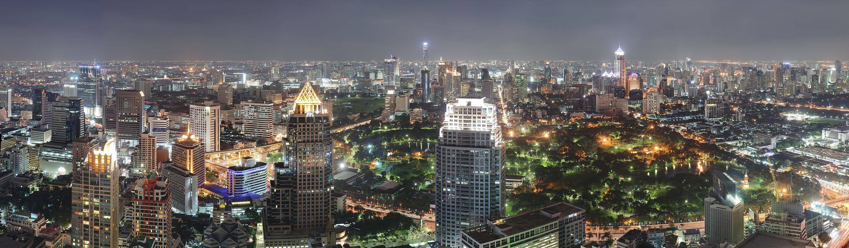 Skyscrapers of the districts Ratchadamri and Sukhumvit at night, viewed across Lumphini Park from the Si Lom – Sathon business district 