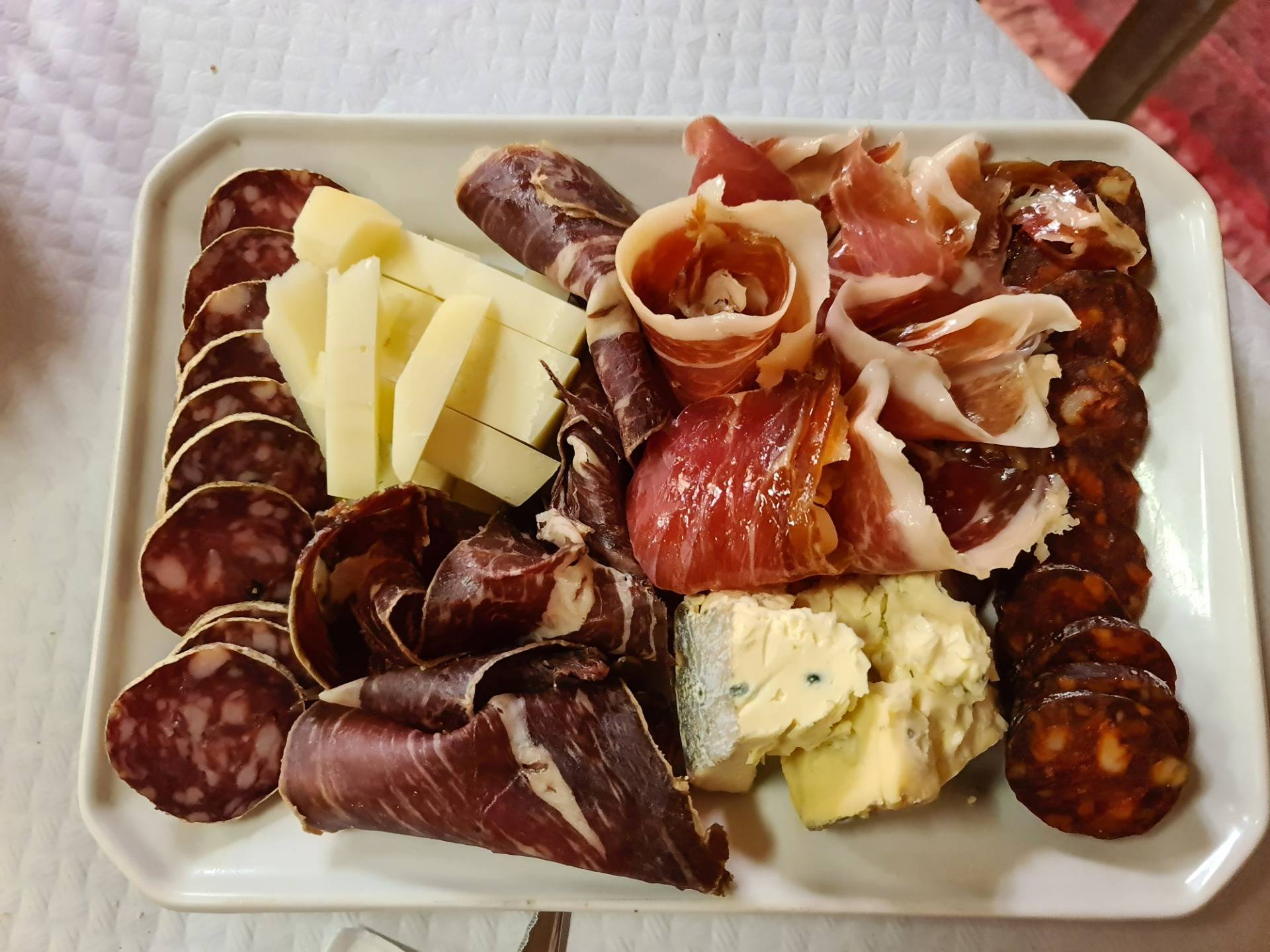Half board of assorted artisan cold meat (famouse Leonese beef jerky + smoked Serrano ham) and sausages (cured white and red sausages) and cheeses (blue sheep cheese, Cabrales type + aged cow cheese) - (€12, sided with artisan bread).
