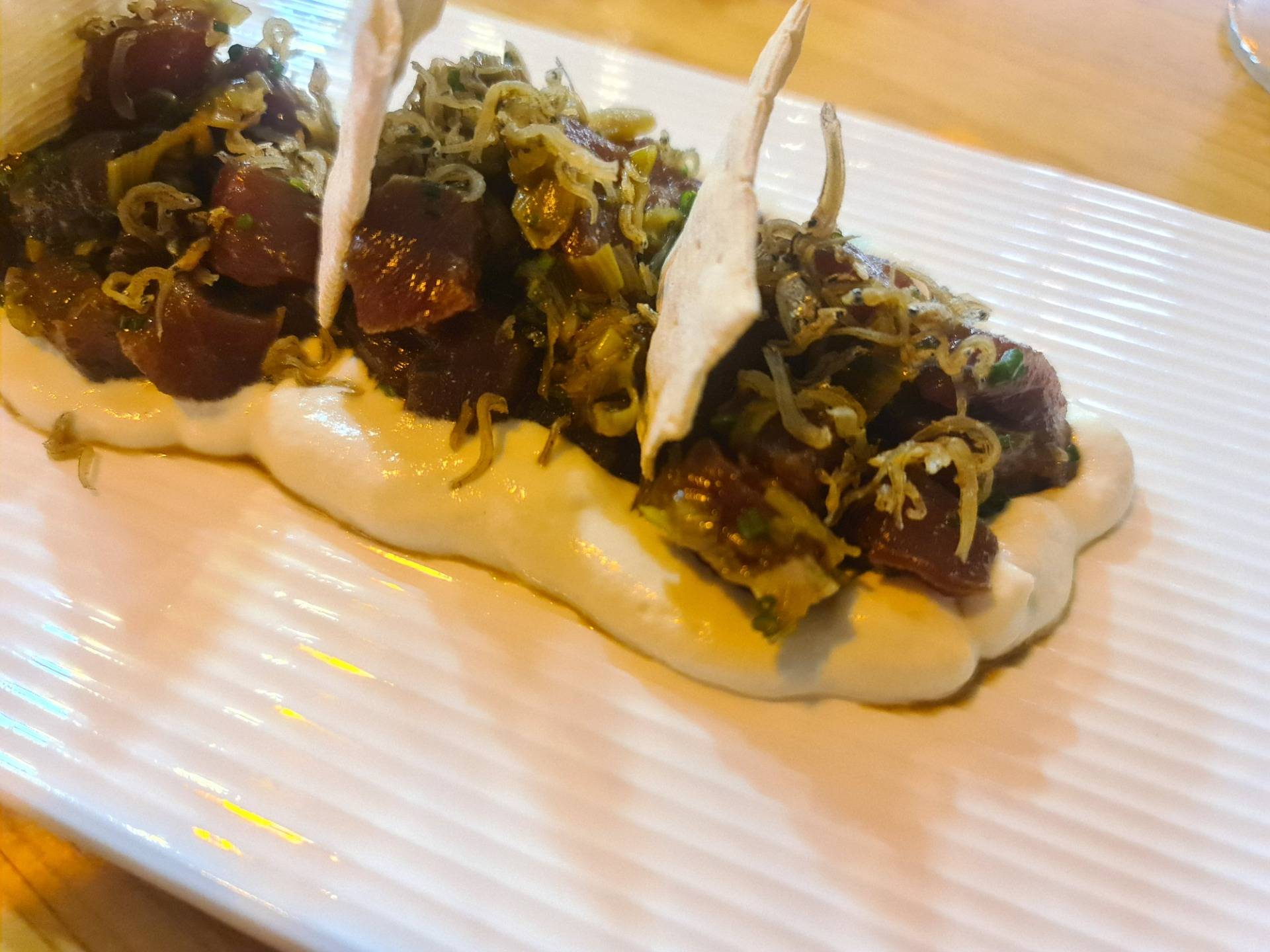 Bluefin tuna tartare on garlic gazpacho cream topped with niboshi, poached onion on a sherry reduction and ”regañá” crackers (€18.50) (3).
