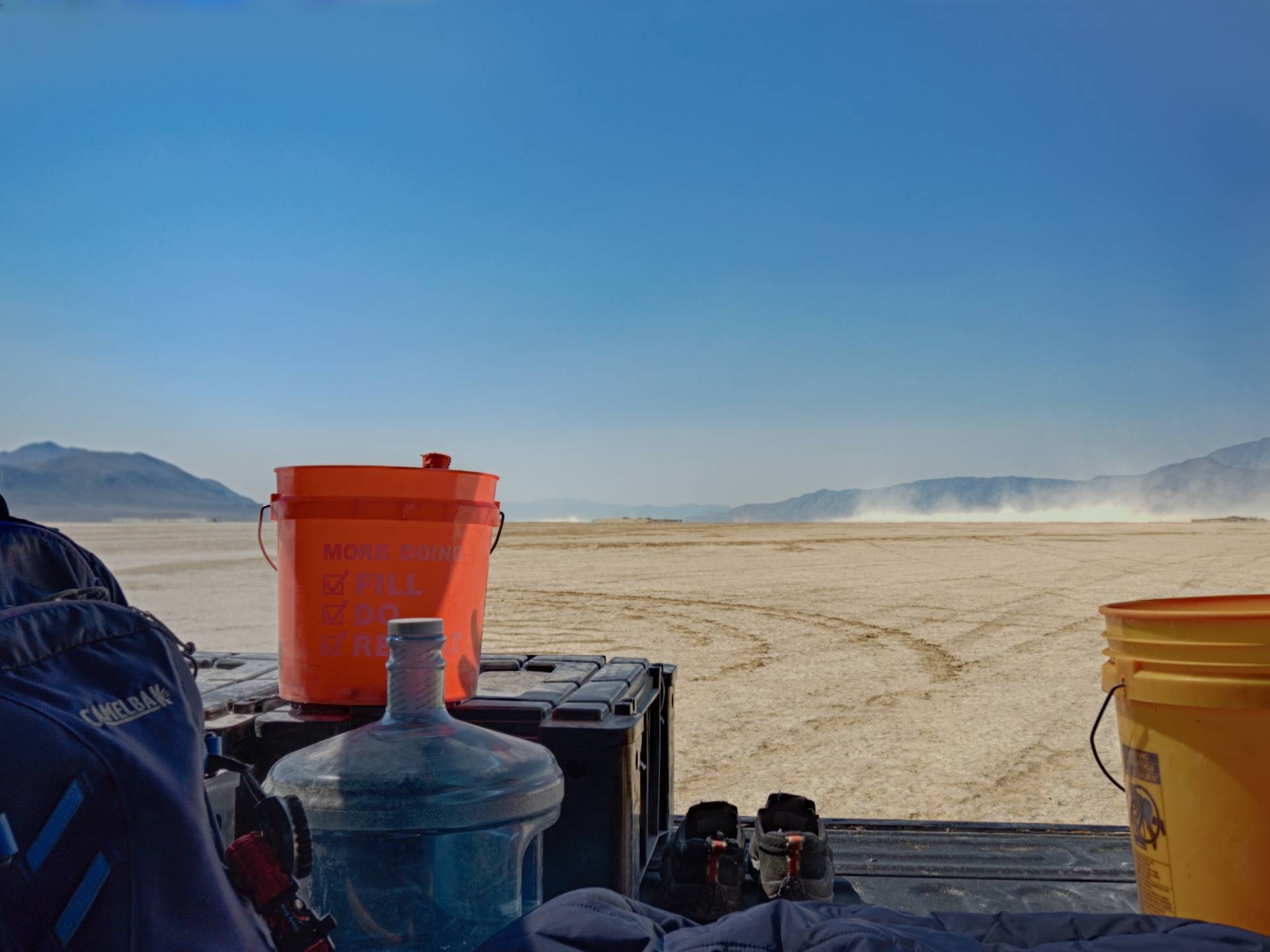 Truck glamping. The playa is alkali flat and hard on the skin. It was too hot for shoes, so I hid out in the bed of the truck watching and waving to the people driving and flying by.