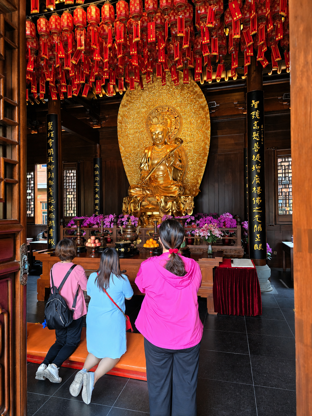Worshippers kneeling before one of the temple’s illuminated shrines.