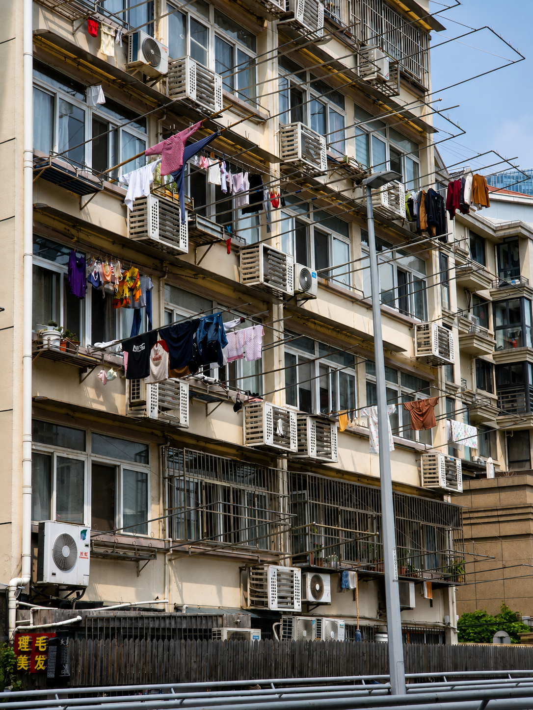 Laundry, air-conditioning units and everyday life on a residential facade.