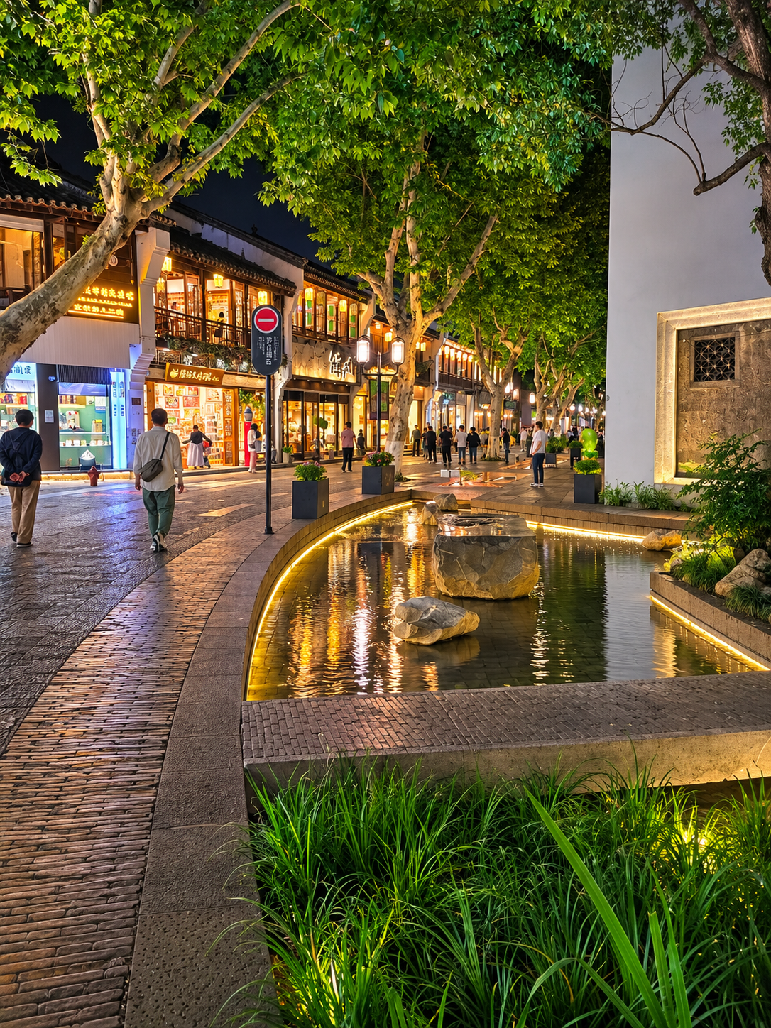 Southern Song Imperial Street at night, where old façades, plane trees and a narrow water channel soften the city into something almost theatrical.