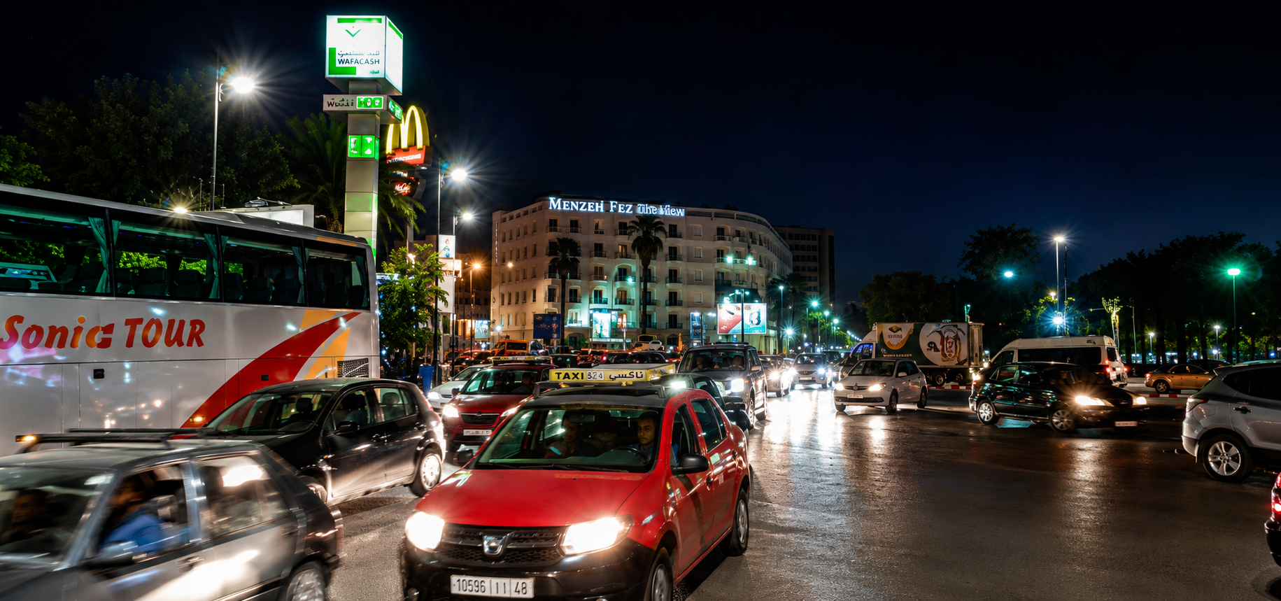 Night traffic in modern Fes — taxis, buses, neon and headlights, a sharp contrast to the medieval medina I had been wandering through only hours earlier.