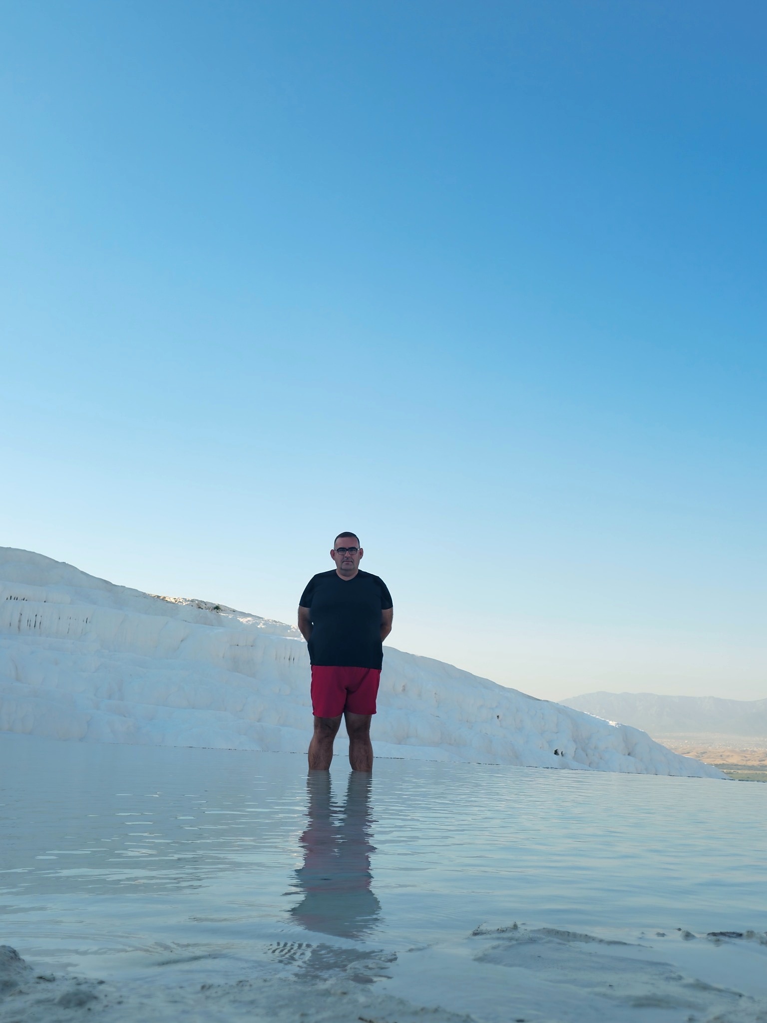 Inside the shallow travertine pools — idyllic in a photograph, slightly less elegant when you are trying not to slip barefoot.