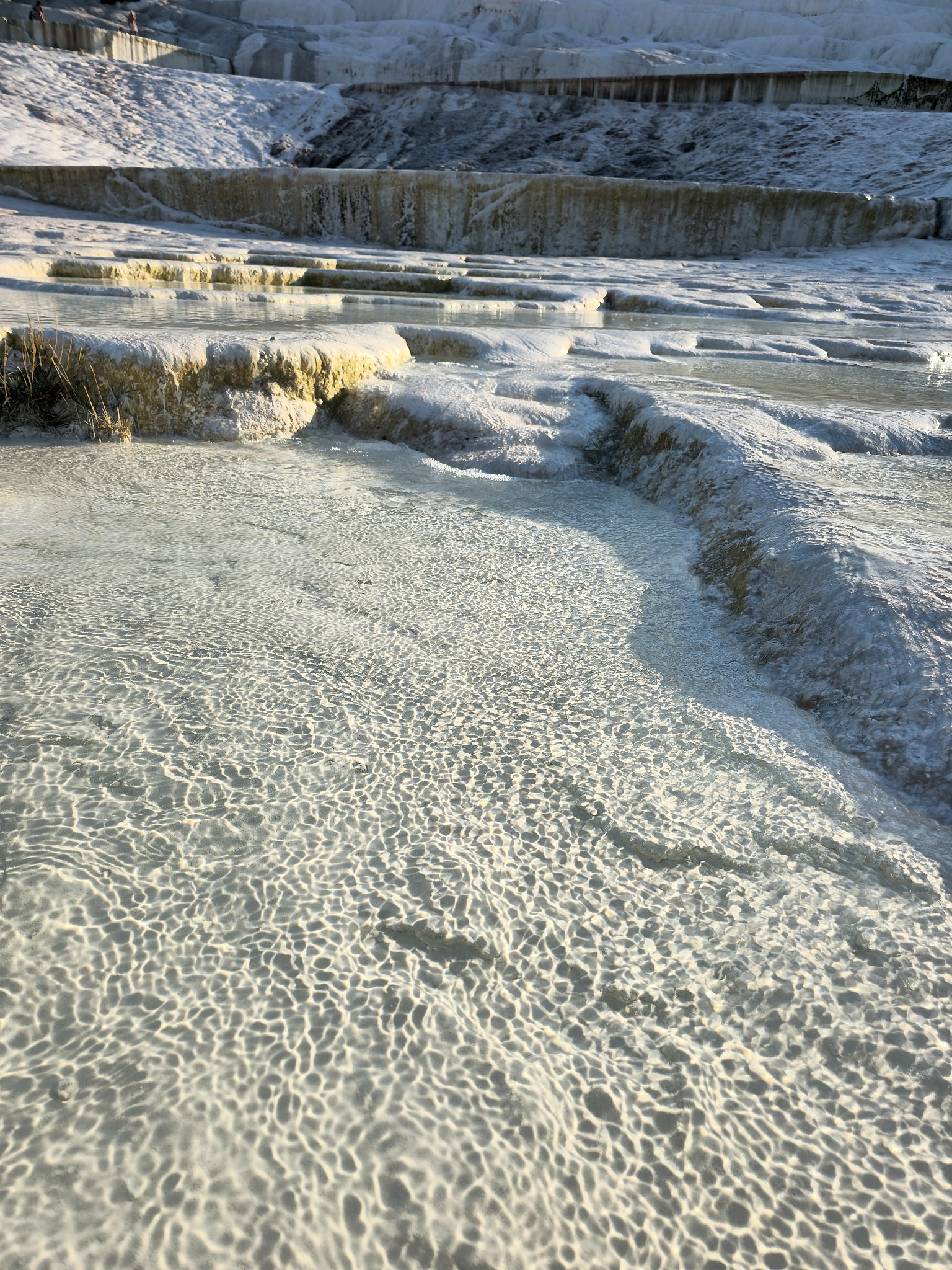 Up close, Pamukkale is less like cotton and more like a hard mineral landscape shaped continuously by thermal water.
