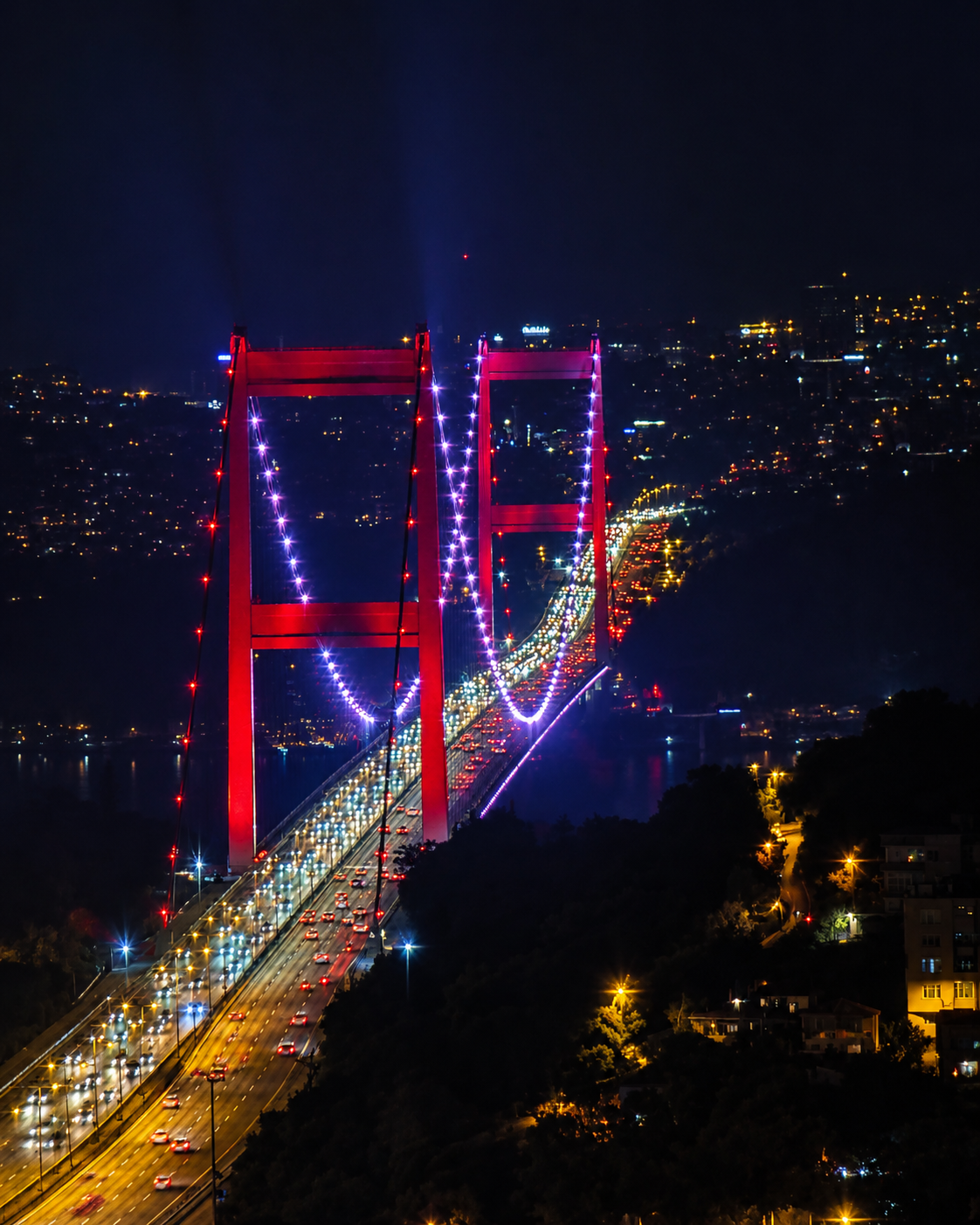 The view that justified every lira: the Bosphorus Bridge glowing below my suite after dark.