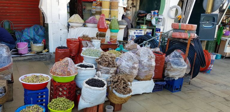 Spices, olives, dried goods and coiled hoses displayed outside a shop in Moulay Idriss medina.