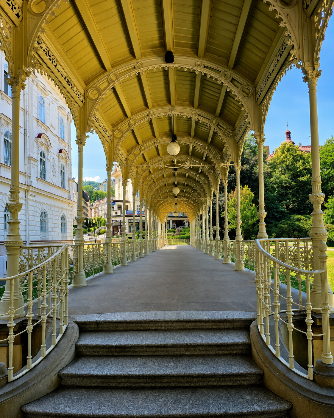Ornate cast-iron colonnade with steps and hanging lamps in Karlovy Vary, Czechia