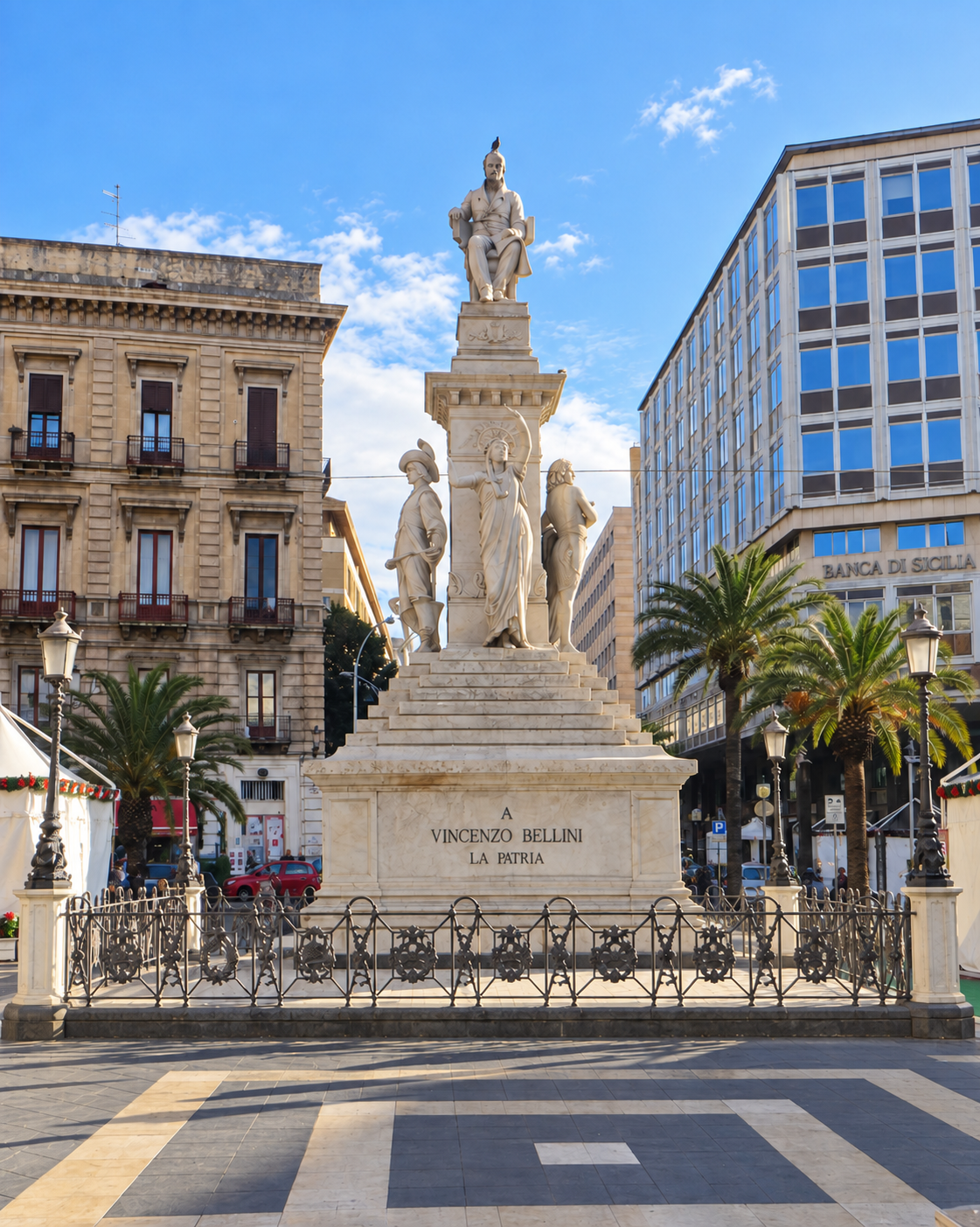 Vincenzo Bellini monument in Piazza Stesicoro, Catania, with allegorical statues and palm trees.