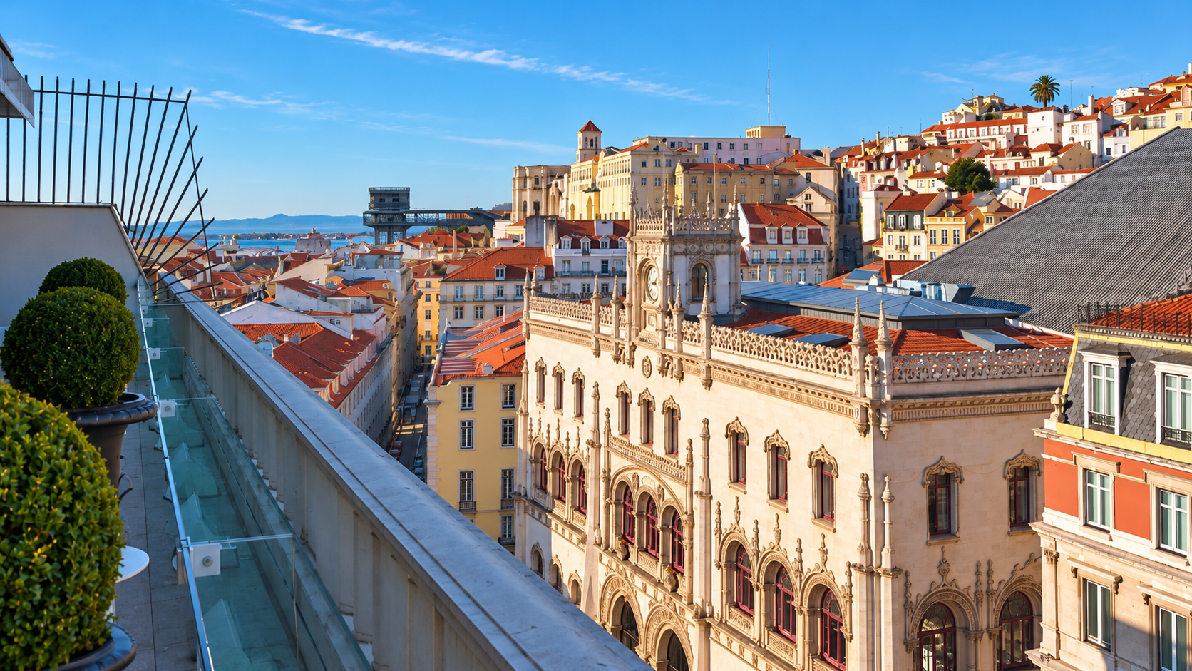 Lisbon rooftops and the ornate Rossio railway station facade seen from a rooftop terrace.