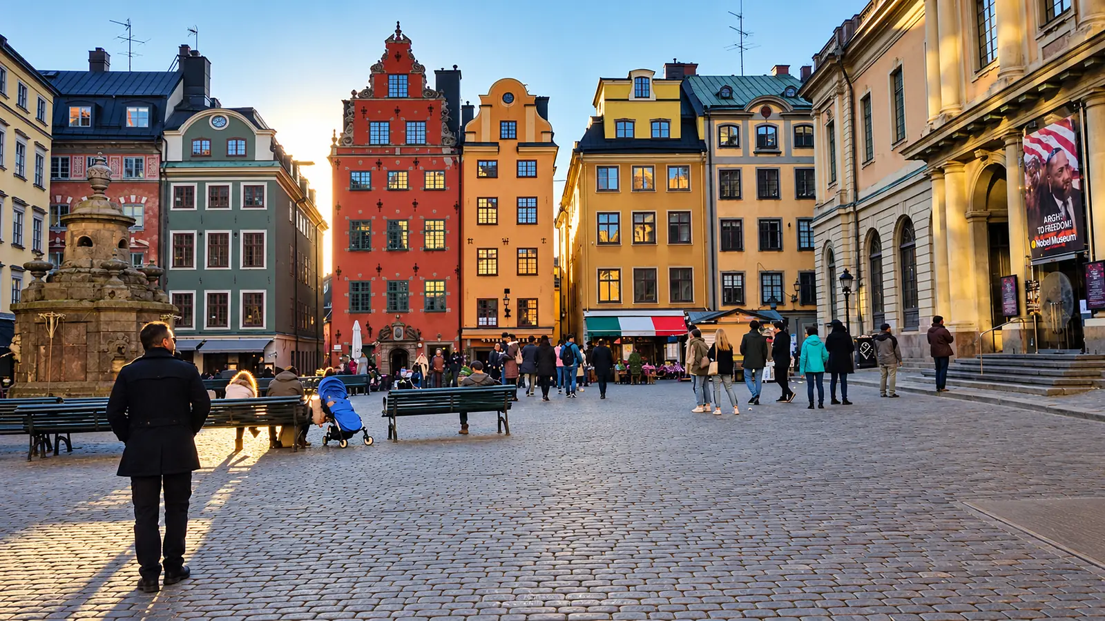 Colourful historic buildings surround Stortorget square in Stockholm’s Gamla Stan, with pedestrians crossing the cobblestones.