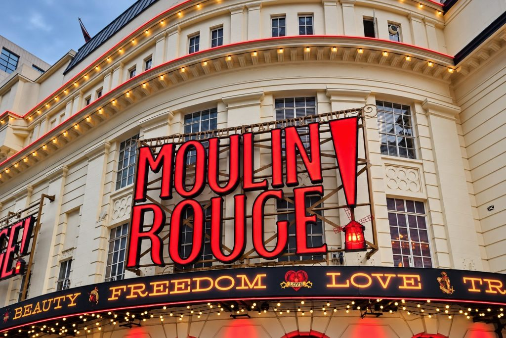 Moulin Rouge! sign on the ornate Piccadilly Theatre facade in London.