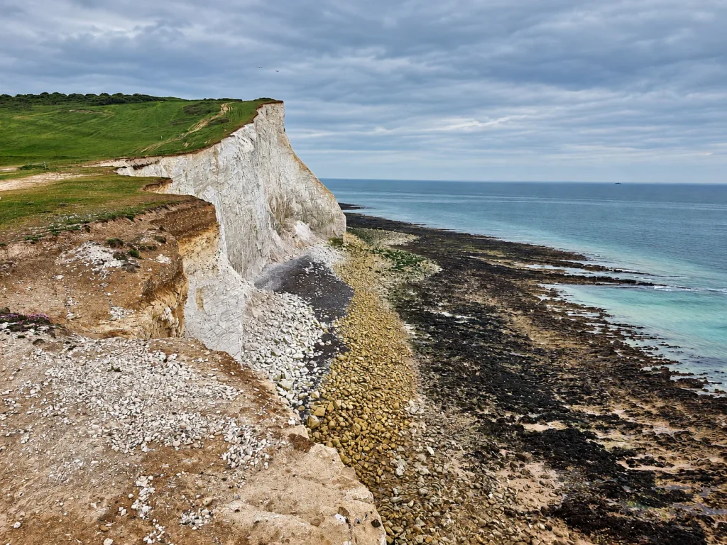 White chalk cliffs and rocky shore along the Seven Sisters coast in East Sussex.