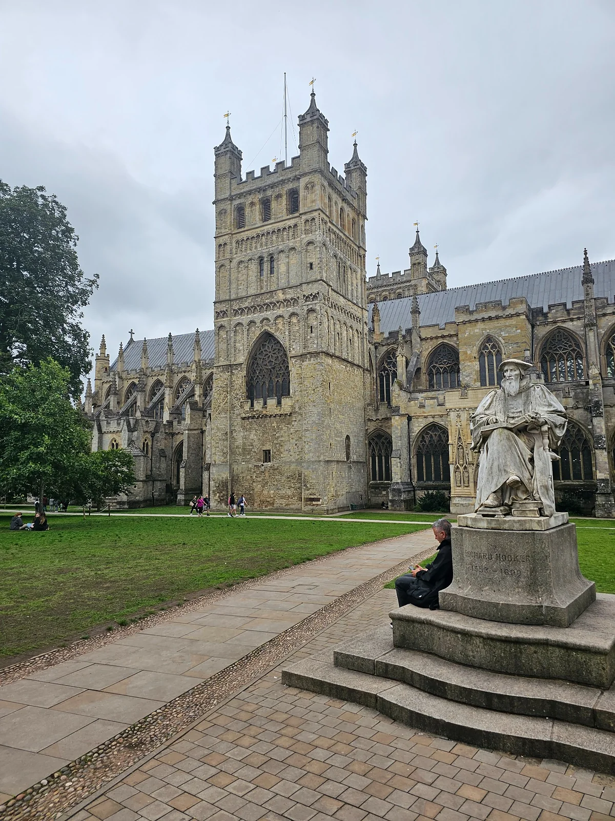 Exeter Cathedral and a statue of Richard Hooker in the cathedral grounds.