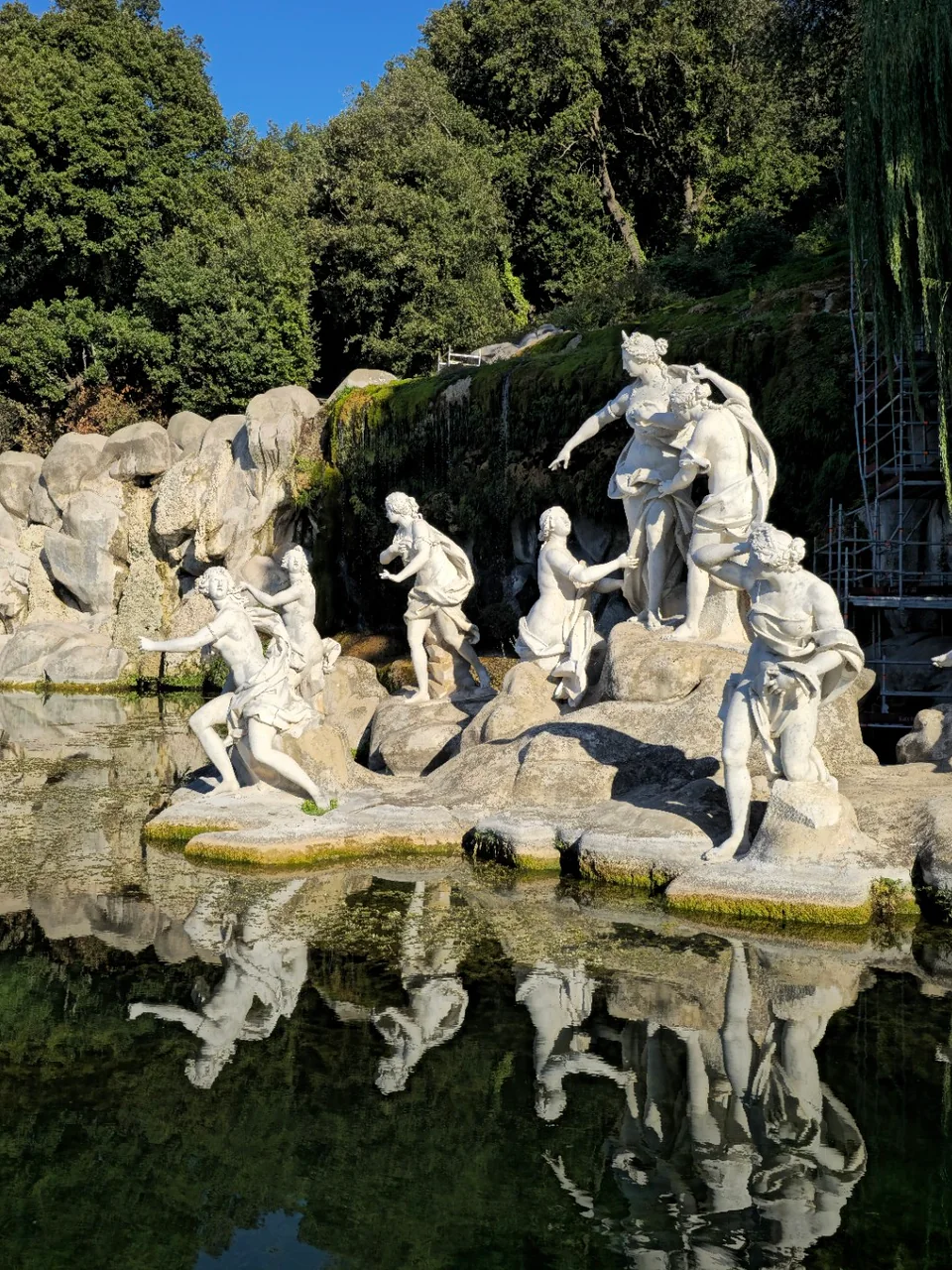 Diana and nymphs stand on rocks beside a reflective pool in Caserta’s park.