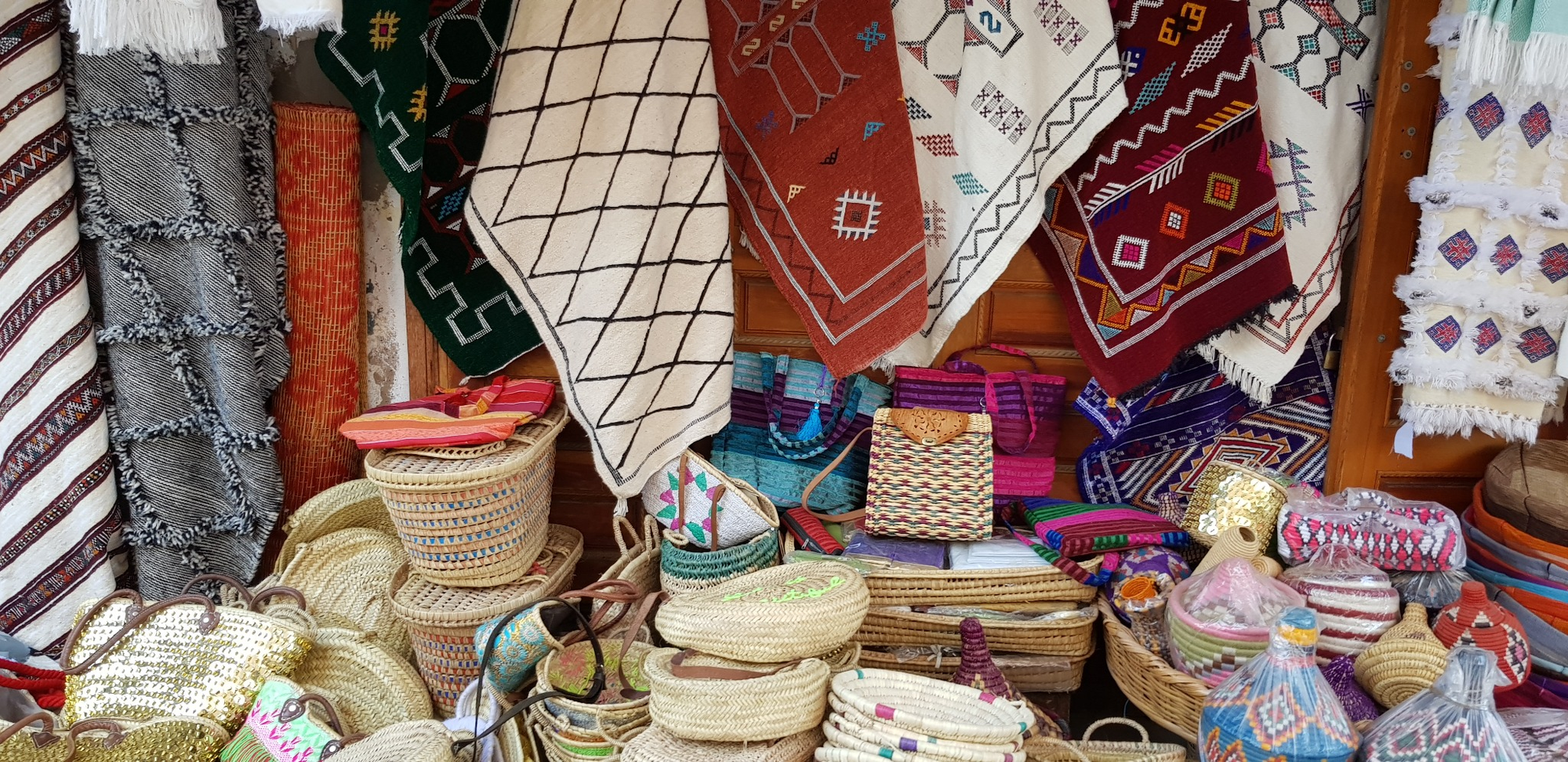 Woven baskets, rugs, and embroidered textiles fill a market stall in Rabat’s kasbah.