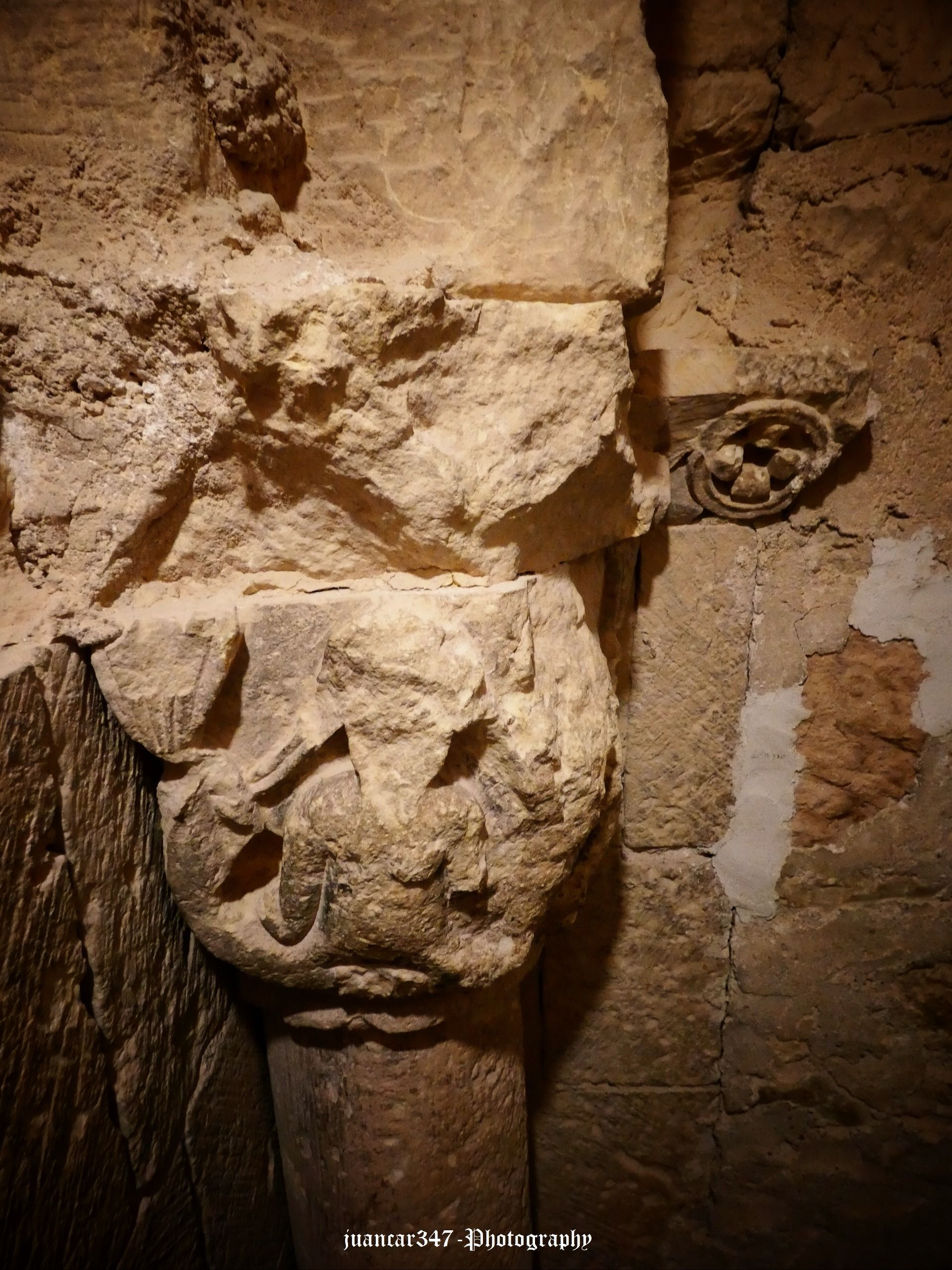 Romanesque capital, albeit shattered, showing a two-tailed mermaid