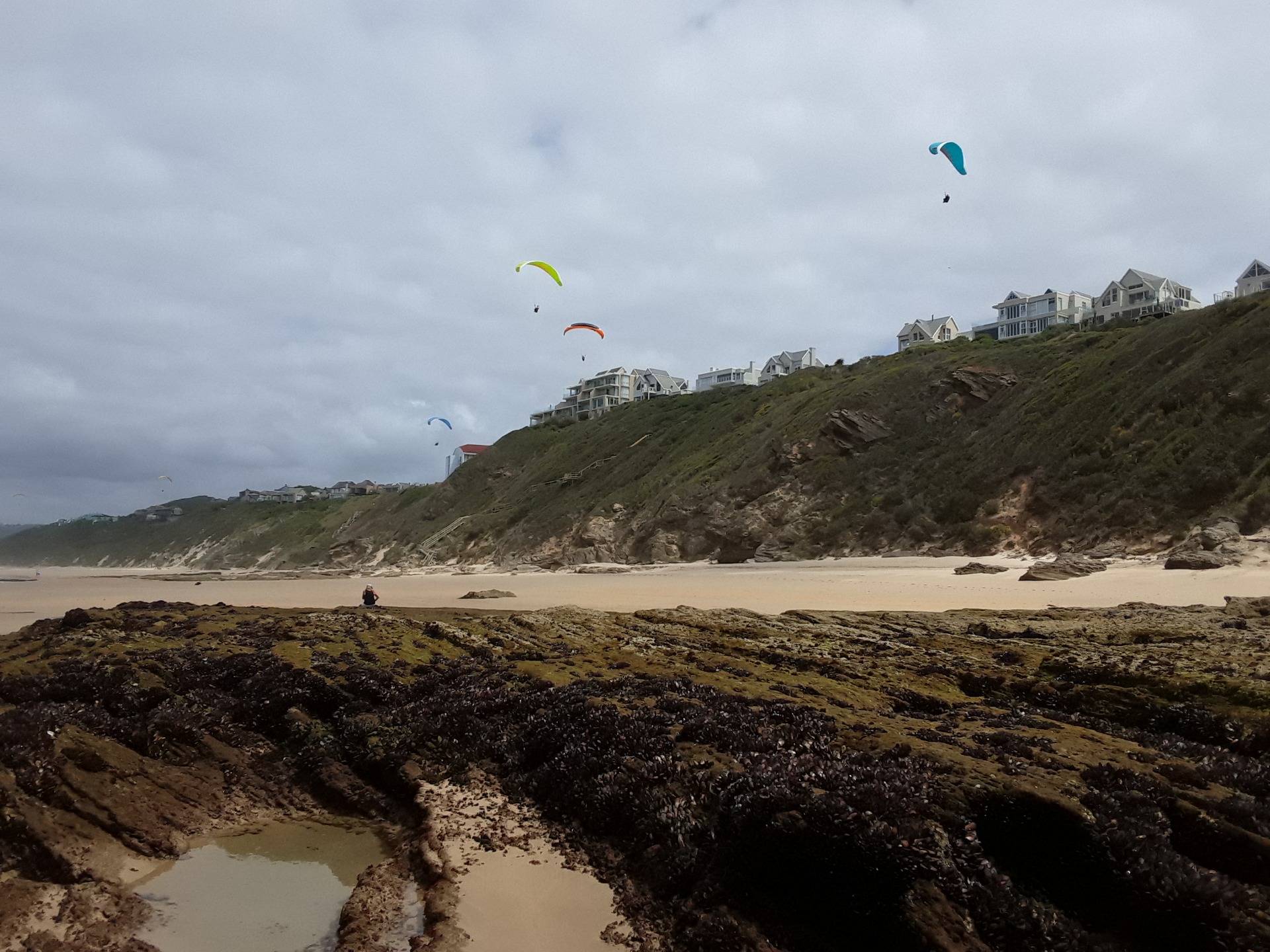 Paragliding and rock pool explorations at Wilderness beach on the south Cape coast of Africa 