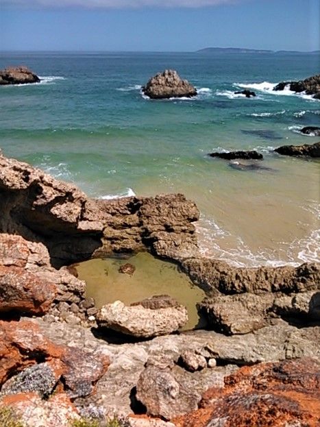 The rock pool from above with Robberg Peninsula in the distance, facing west.