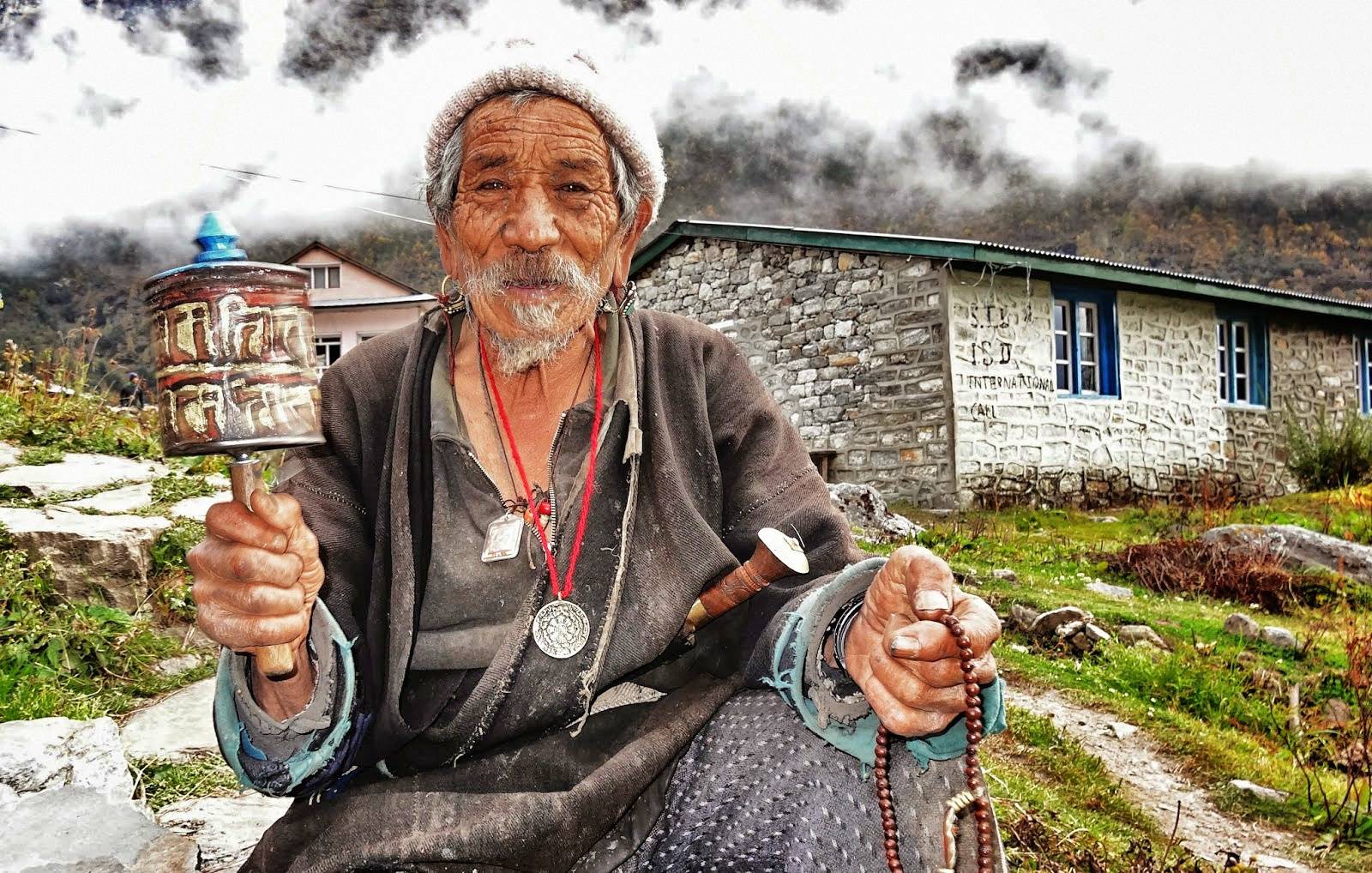 This old man turns a prayer wheel all day long.