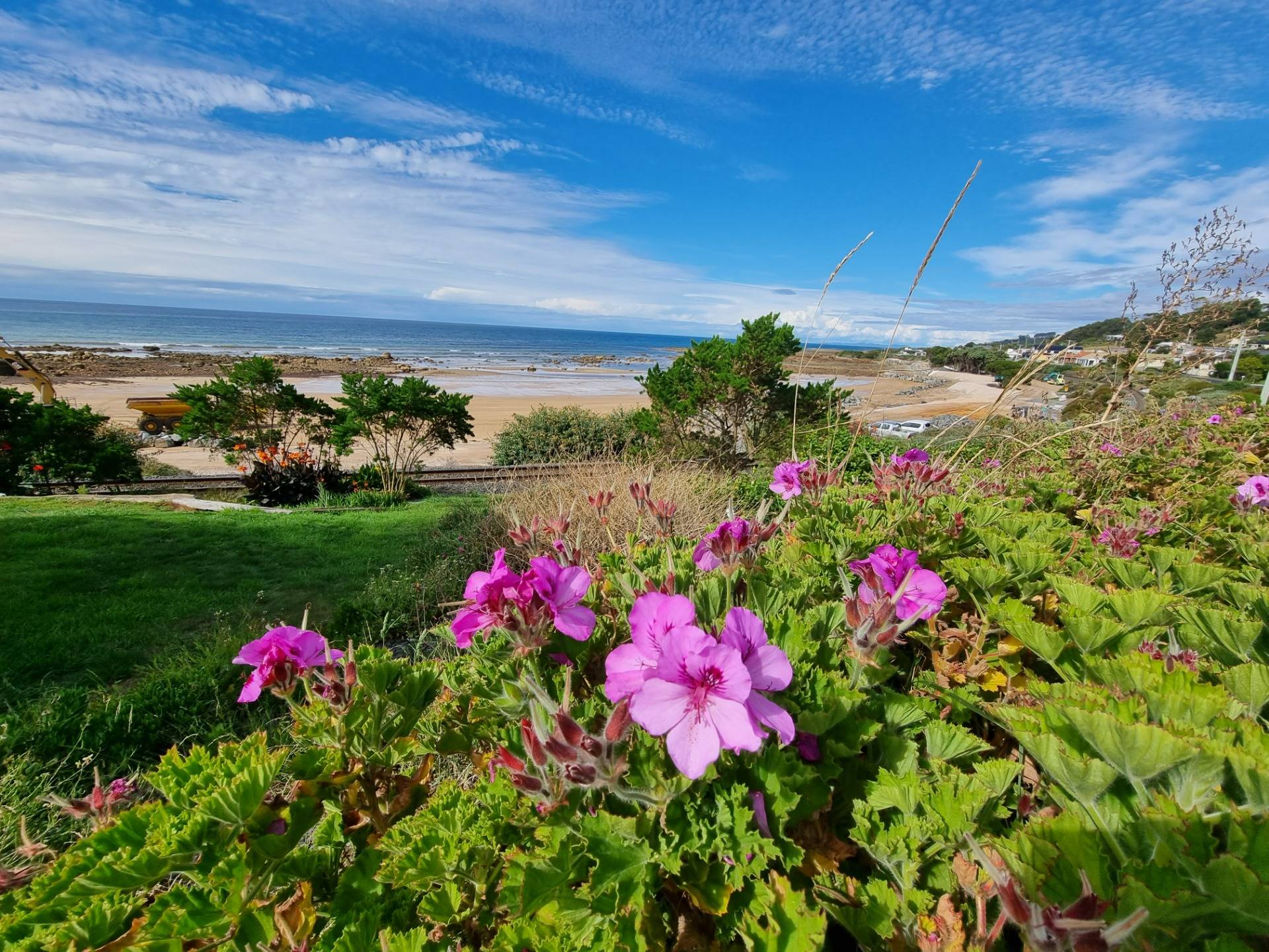 Blue skies, locals’ gardens and a view of one of the small beaches in town.