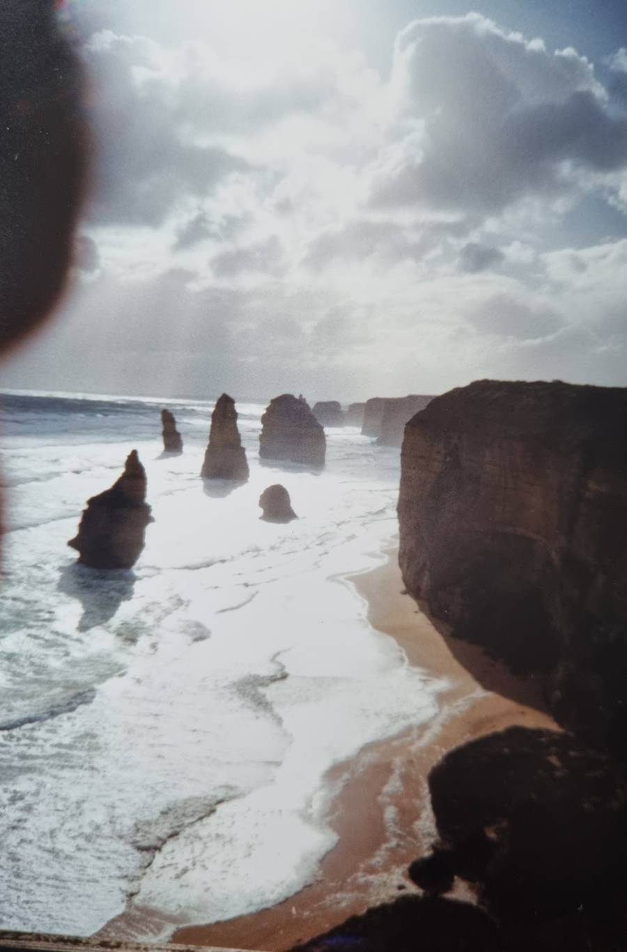 The 12 Apostles, I believe the closest one pictured has now fallen. The sun poked through at just the right time for a photo but I think I had my finger too near the lens trying to hang onto the camera in all the wind.