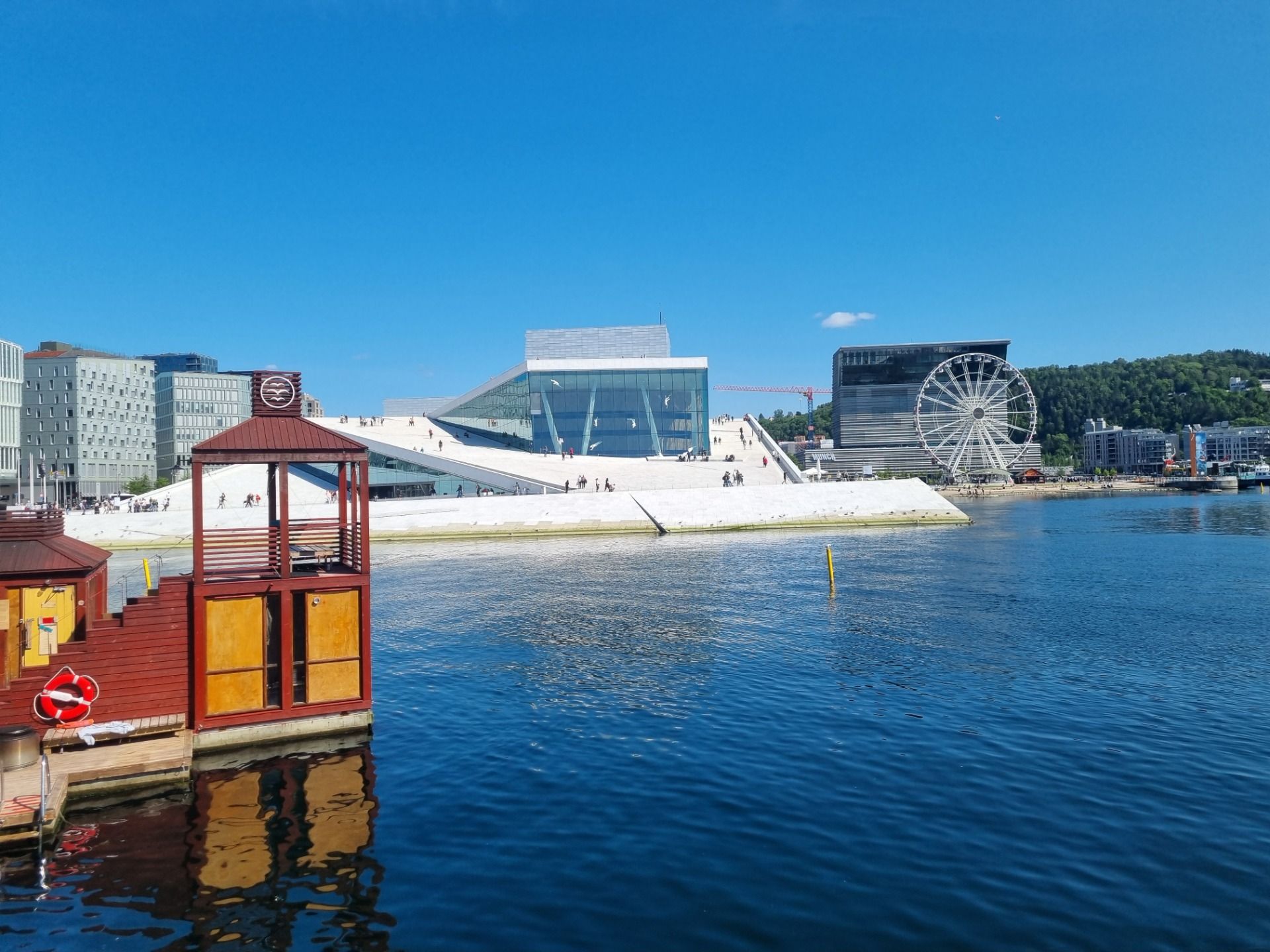 We have seen the Oslo Opera house on many you tube clips. It was even more impressive in real life. The Italian white marble from Carrara was so bright on a very sunny day. It sort of rose like an ice burg out of the bay. They reckon it gets covered in ice and snow in winter, it would be fun to ski or slide down. It reminds me a bit of the Sydney Opera House back home. The shape is completely different but in a prominent position right on the water makes it very similar. I like the look of the Sydney Opera house better, maybe I am a little bias but I loved the fact that you could easily walk to the top of this one in Oslo and get a great view all over the city. We did not go inside but I could have easily enjoyed walking to the viewing points on it’s roof line every day we were there. It was a pretty busy place with international tourists from many different countries photographing the sculptures on the mirrored glass walls.