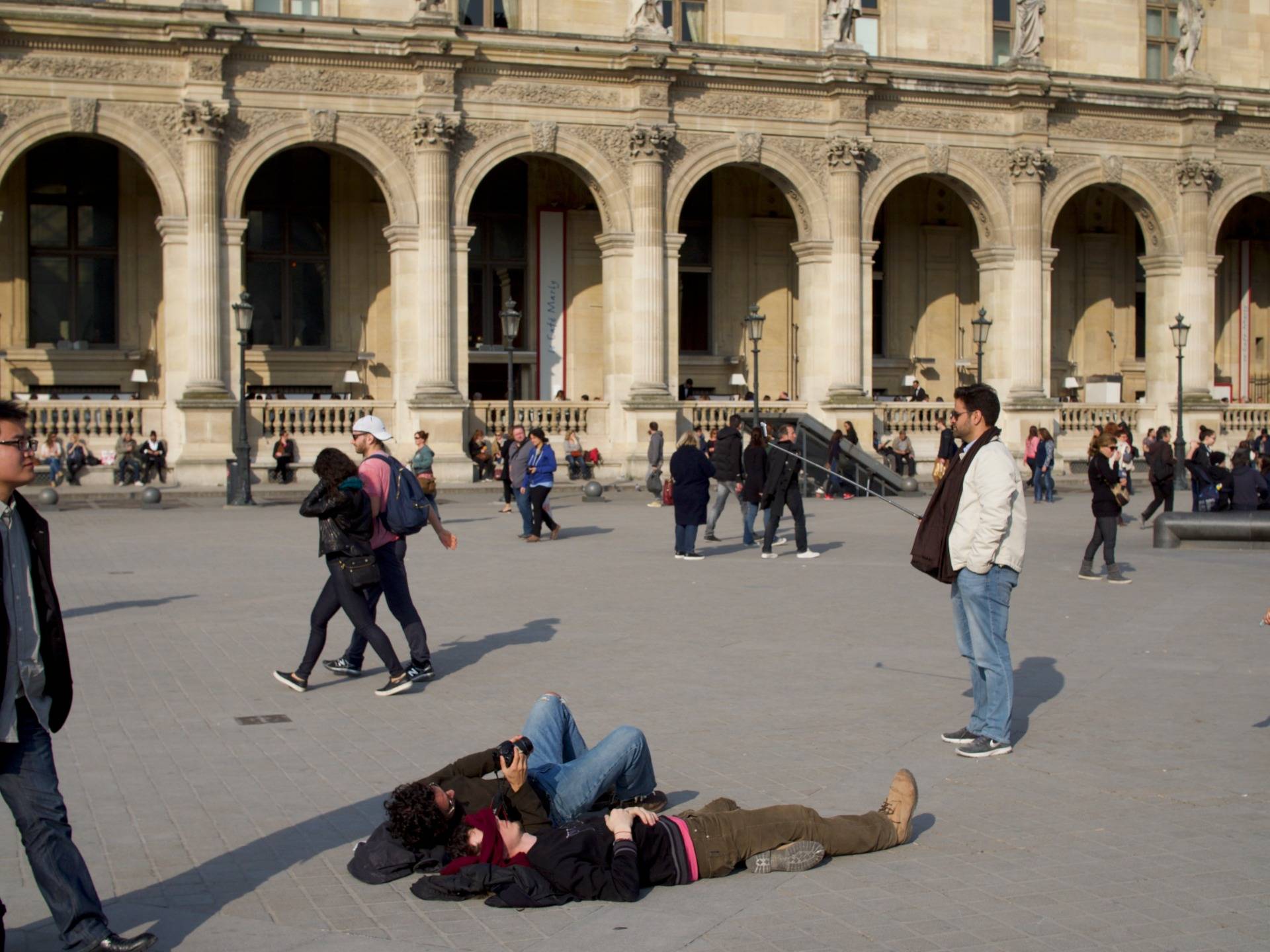 People making selfies everywhere on the square in front of the Louvre
